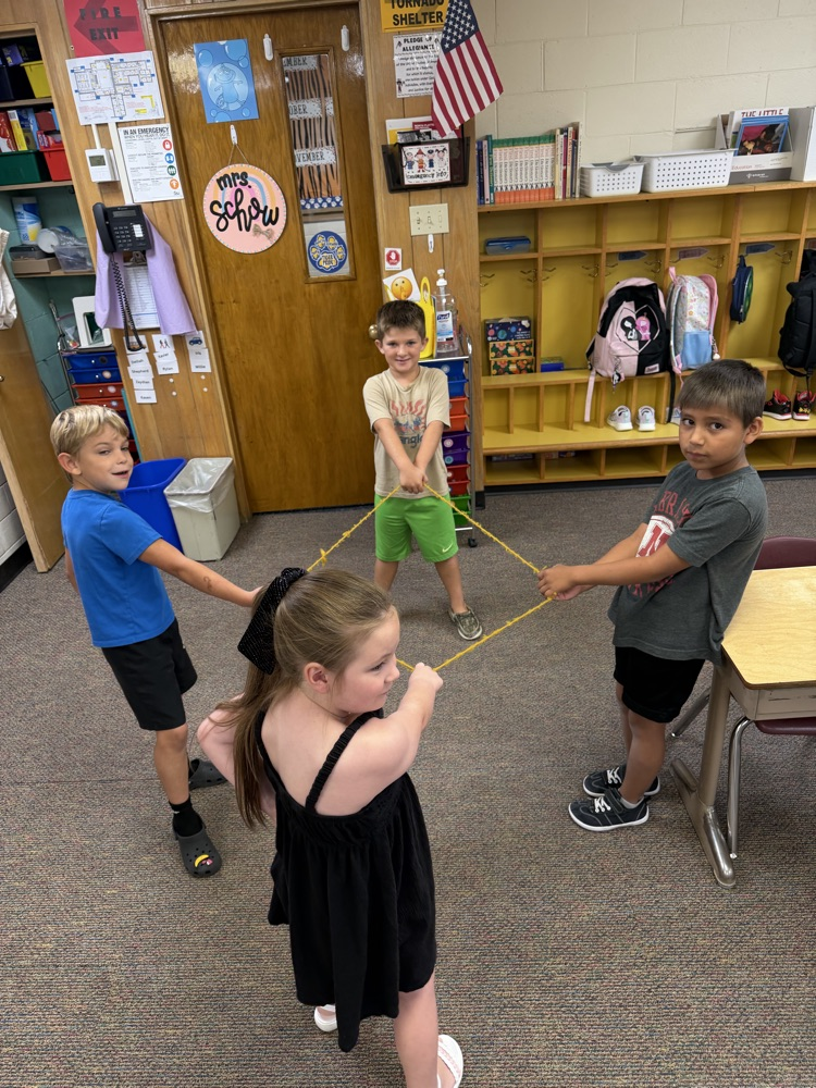 4 students building a shape with a rope