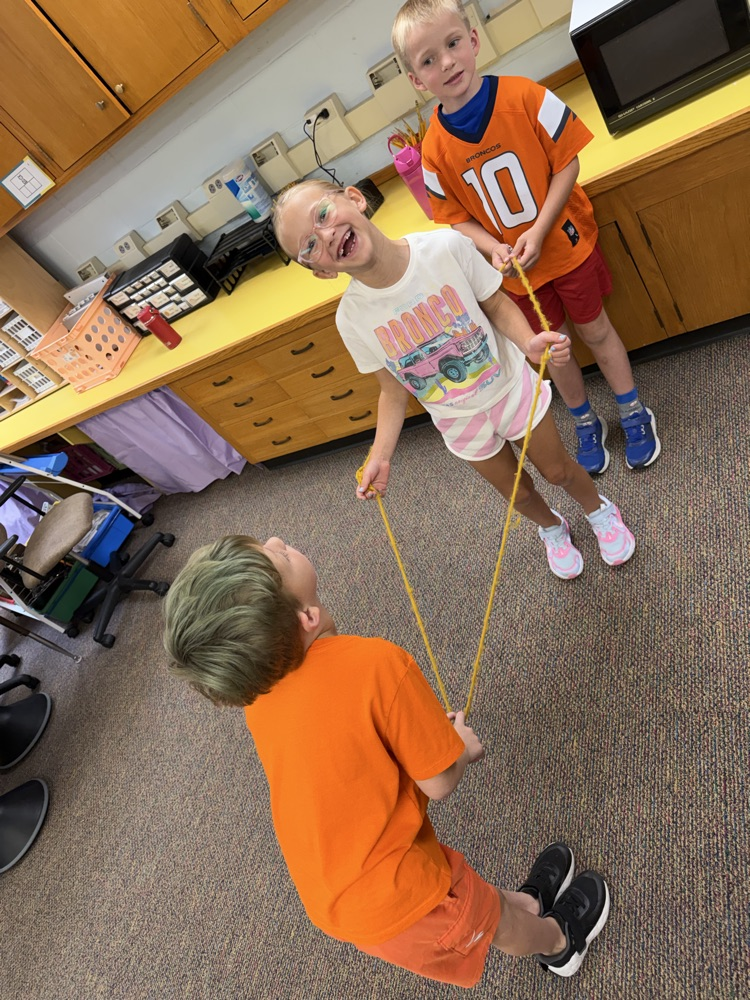 3 students building a shape with a rope