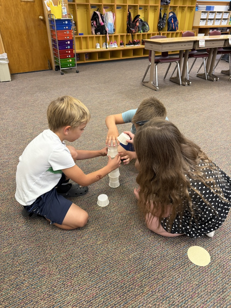 3 students building a cup tower