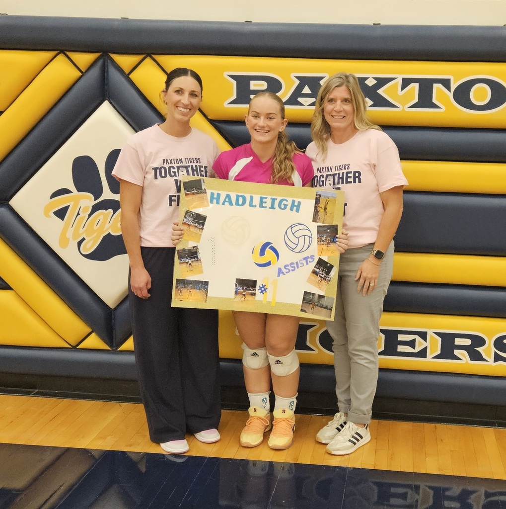 Hadleigh and her Coaches smiling with a poster for her 1000 career assists
