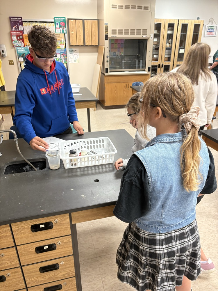 5th grade student working with high school chemistry to complete a physical/chemical change lab