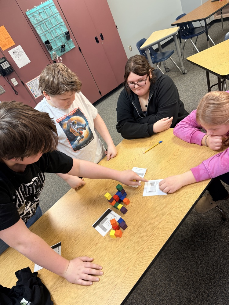 students working on building a structure out of blocks 