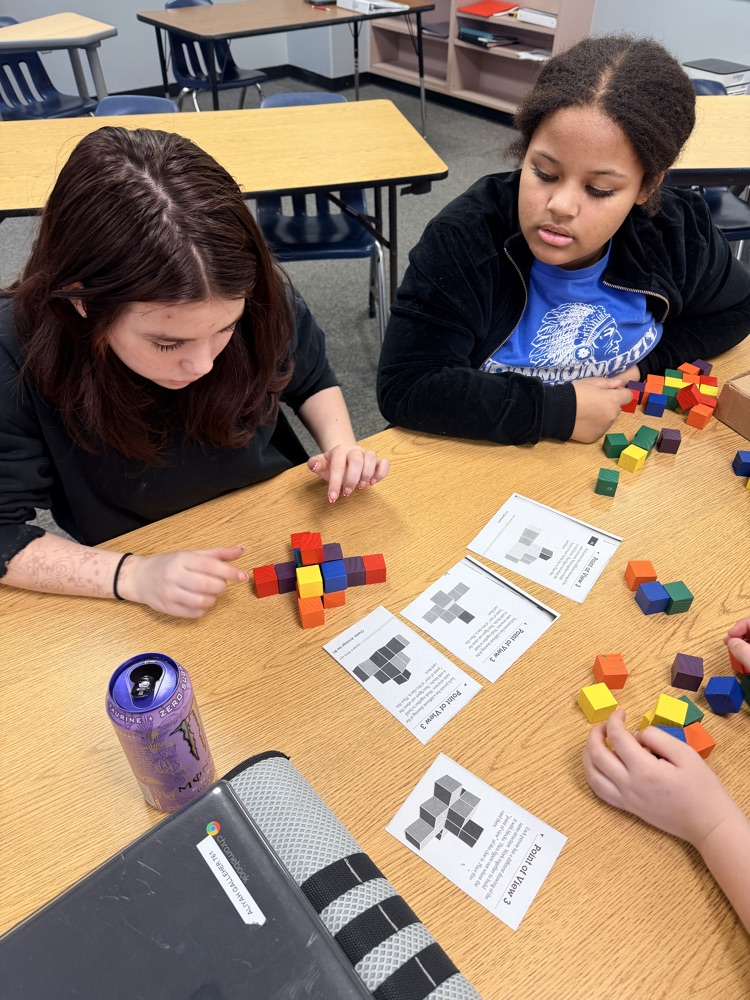 students working on building a structure out of blocks 