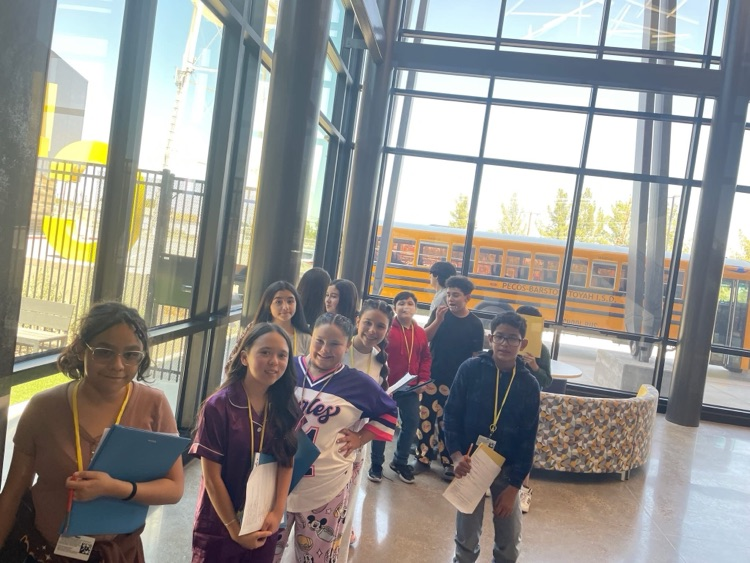 Students are lined up by the window in the CTE lobby smiling.