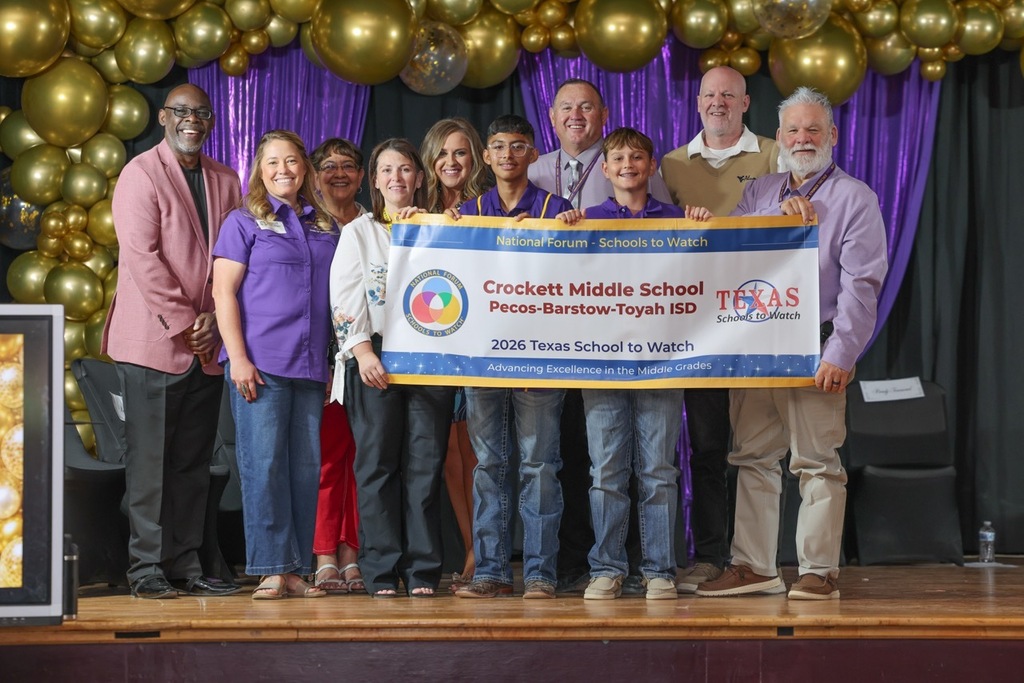 A group of people standing behind a large banner that says "Crockett Middle School Texas Schools to Watch."