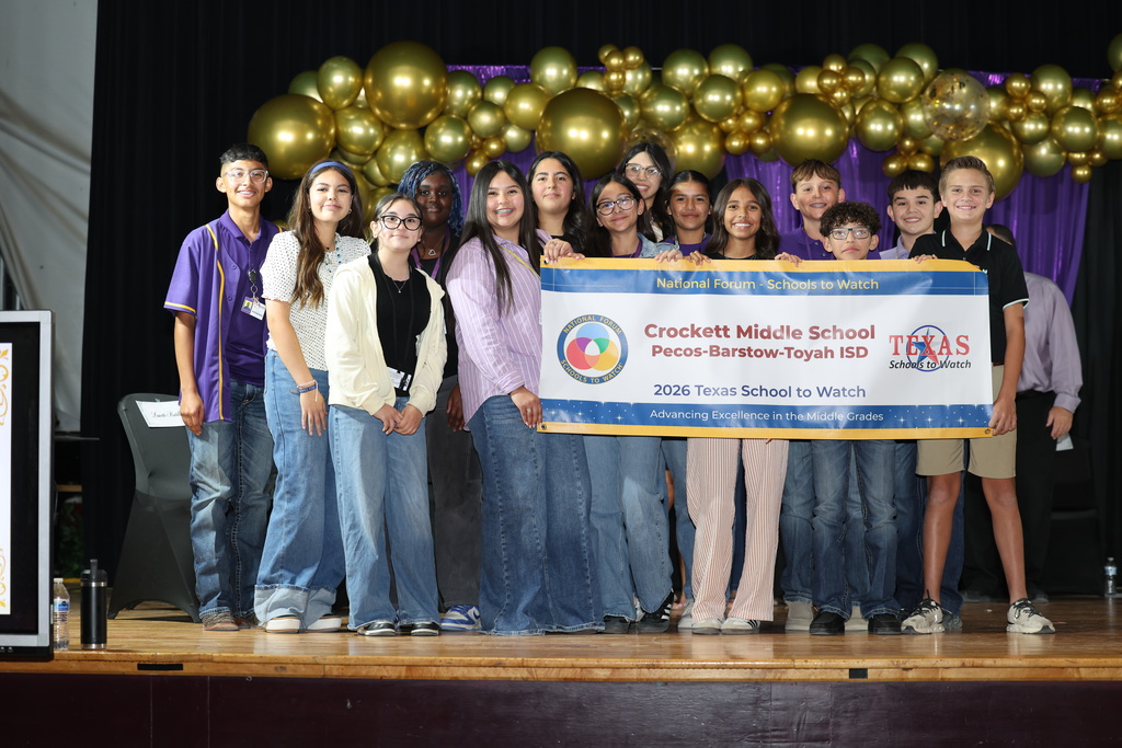 Group photo of students on stage holding a banner for Crockets Middle School's Schools to Watch.