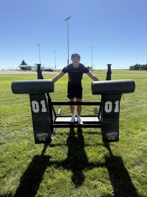 Tanner standing over the football sled
