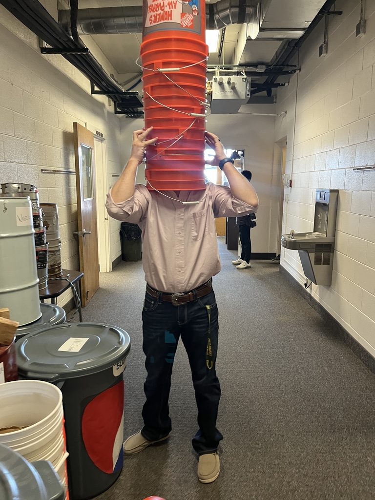 Stack of orange buckets on a persons head