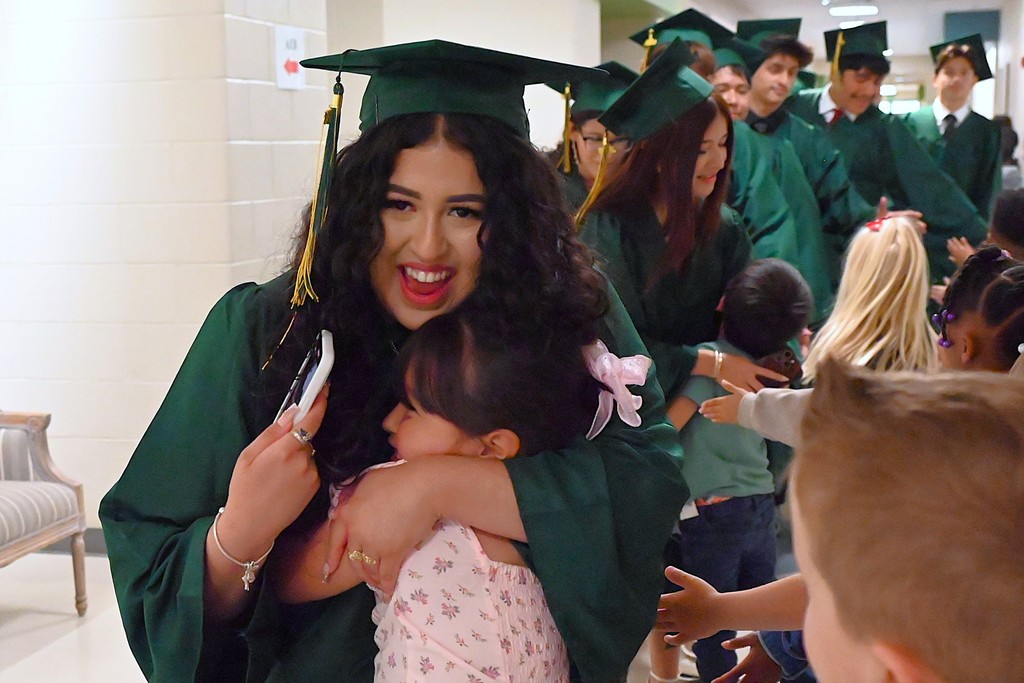 Smiling student hugging a young student