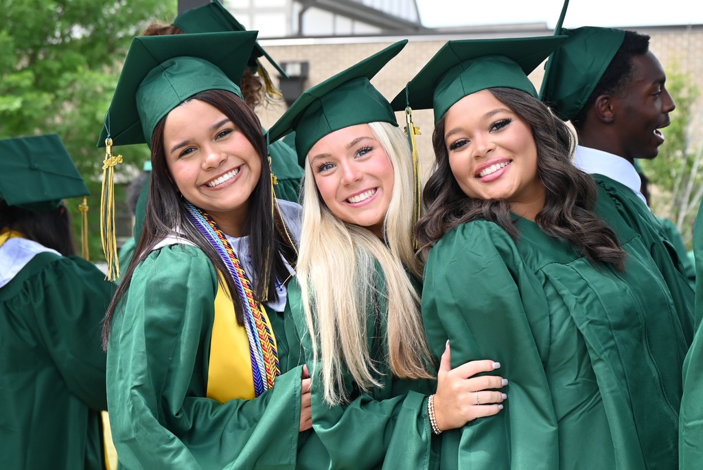 Three smiling girls with cap and gowns on 