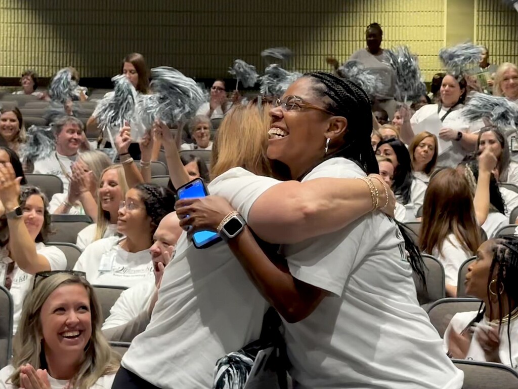 Teachers smiling and hugging
