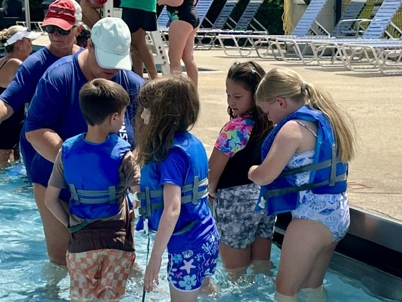 Students with life jackets in the pool