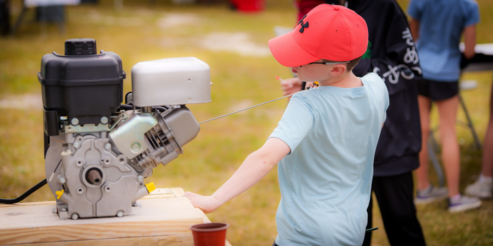 student pulling a cord to start an engine