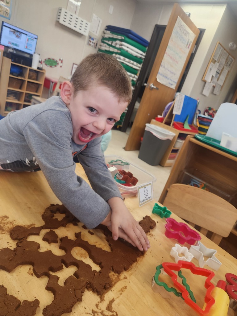 preK student making cinnamon dough for ornaments