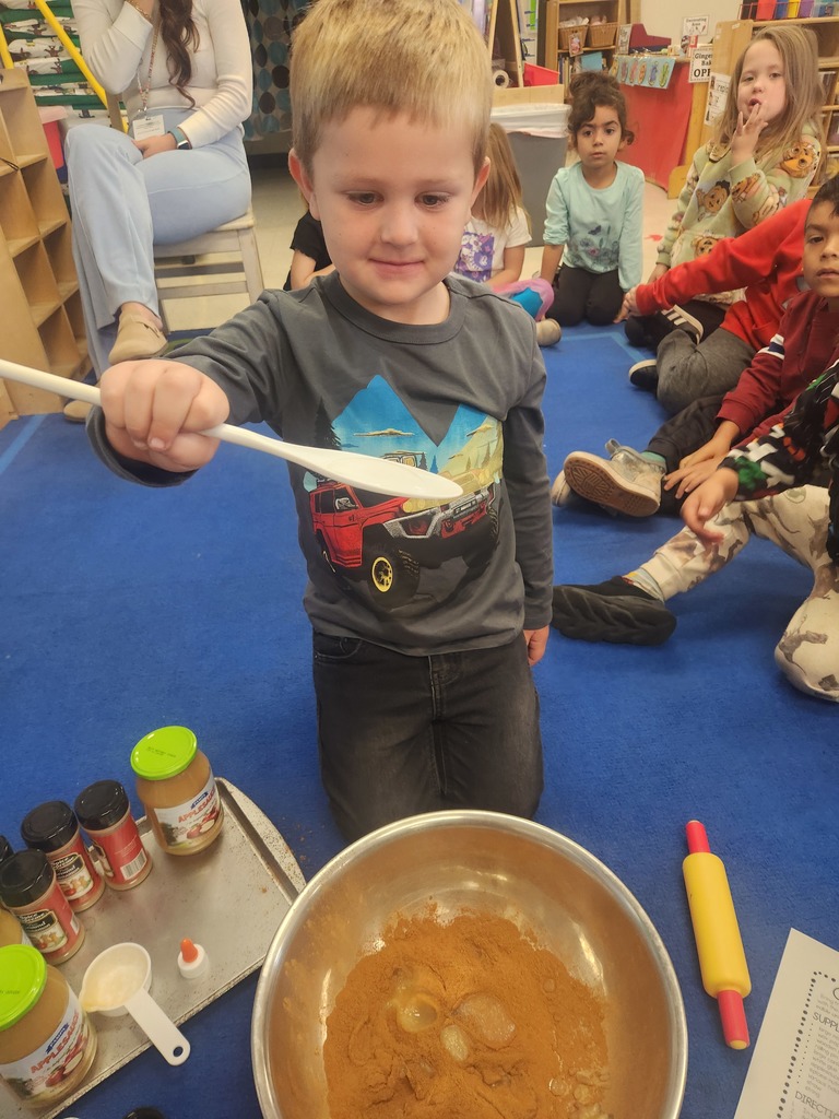 preK student making cinnamon dough for ornaments