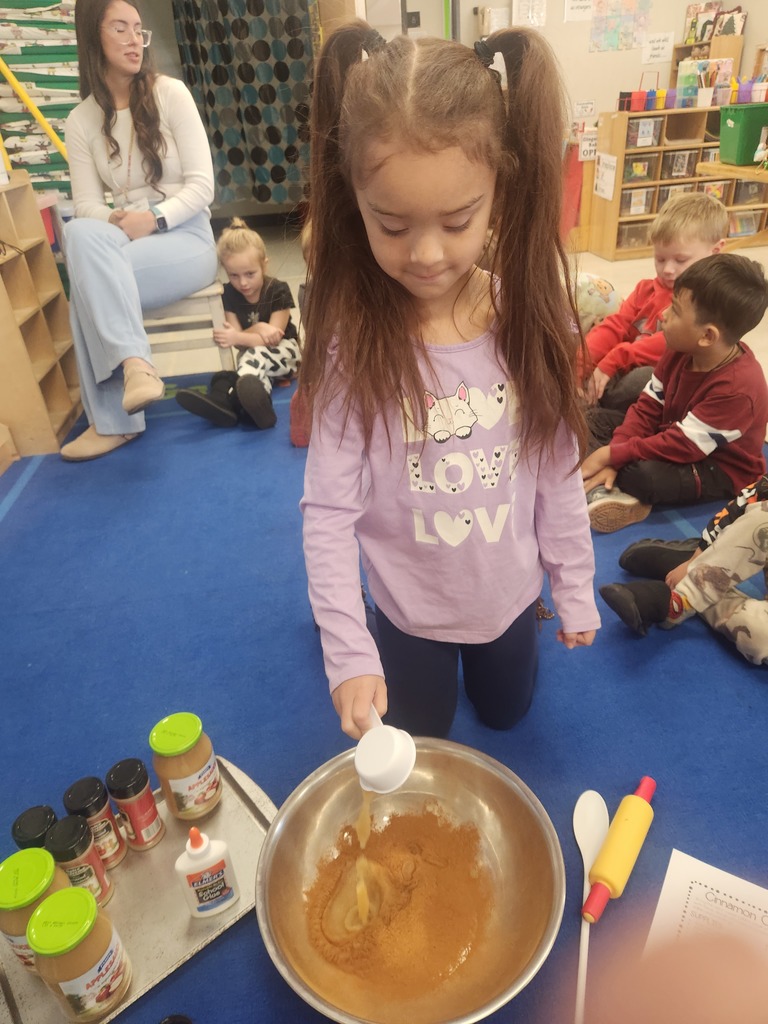 preK student making cinnamon dough for ornaments