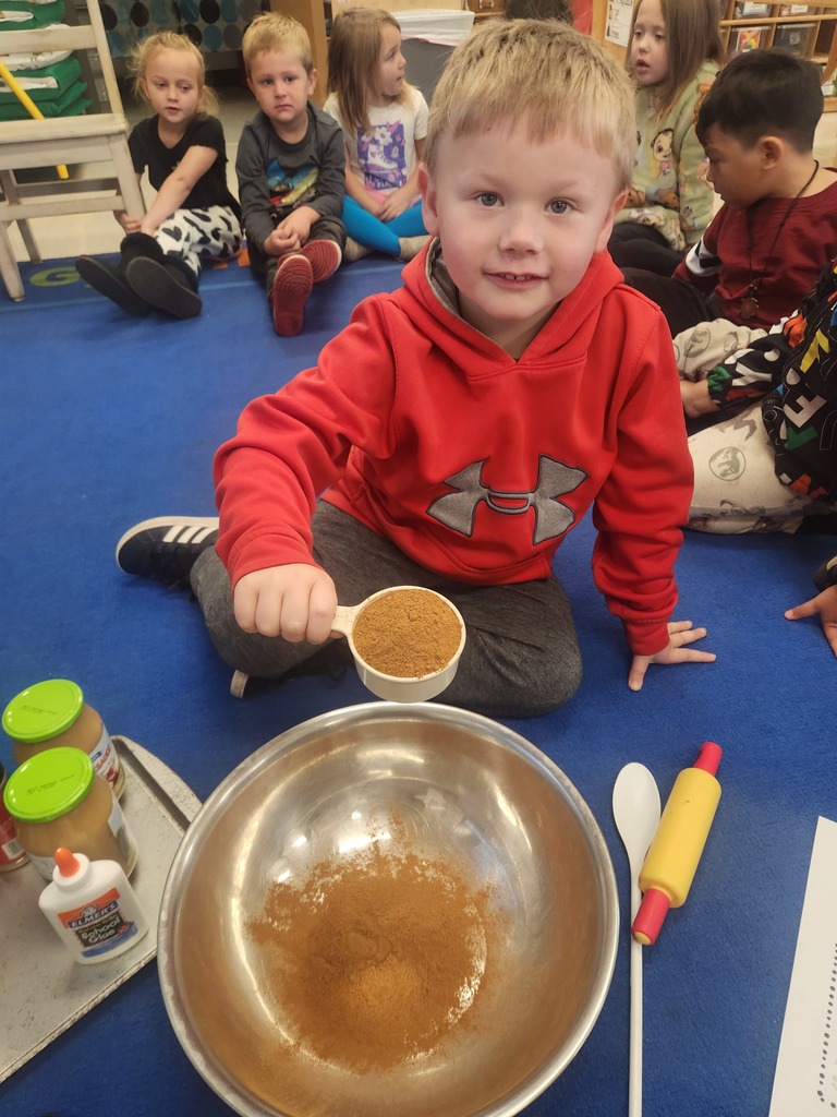 preK student making cinnamon dough for ornaments