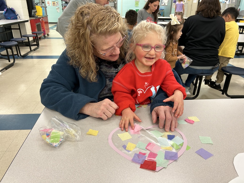 Child doing craft while sitting on grandmas lap