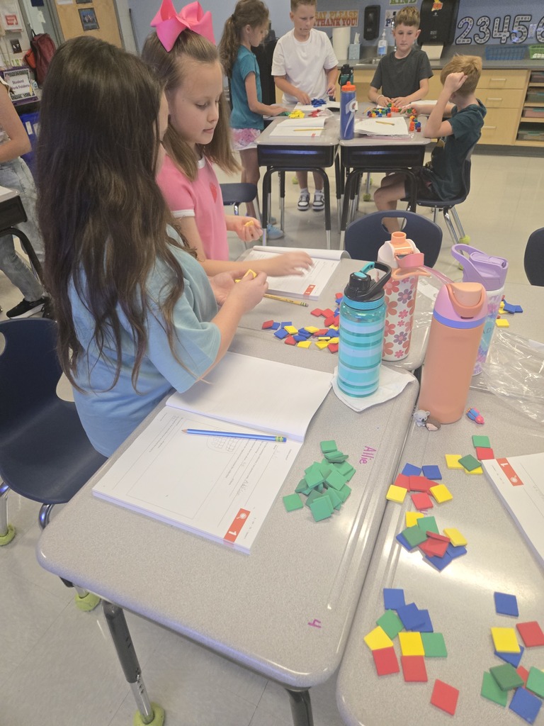 3rd graders working in partners with math manipulatives 