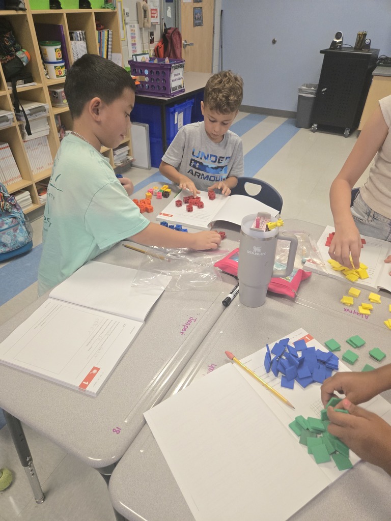 3rd graders working in partners with math manipulatives 