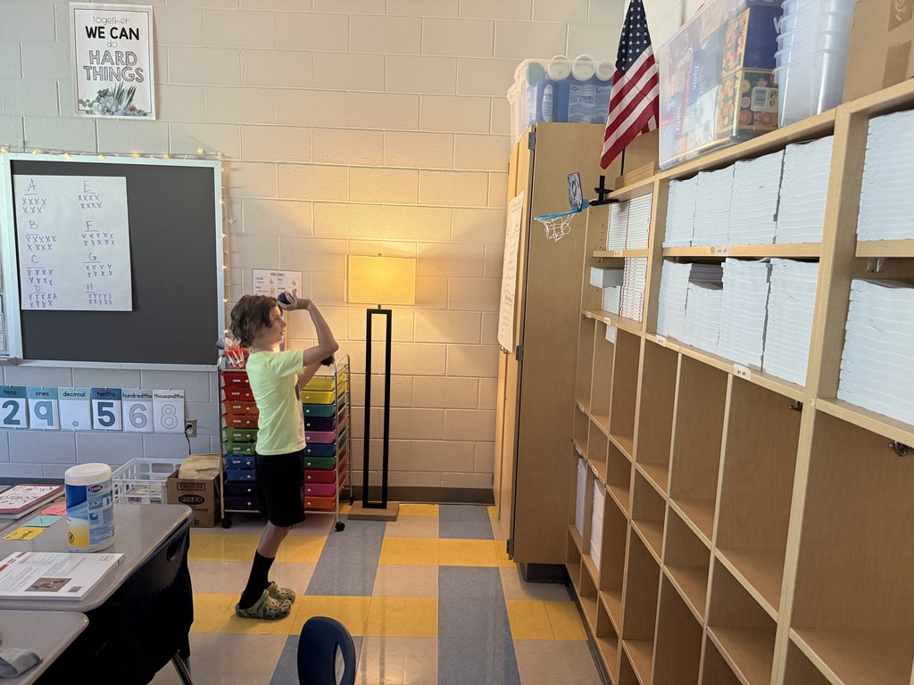 students shooting a ball into a class basketball hoop