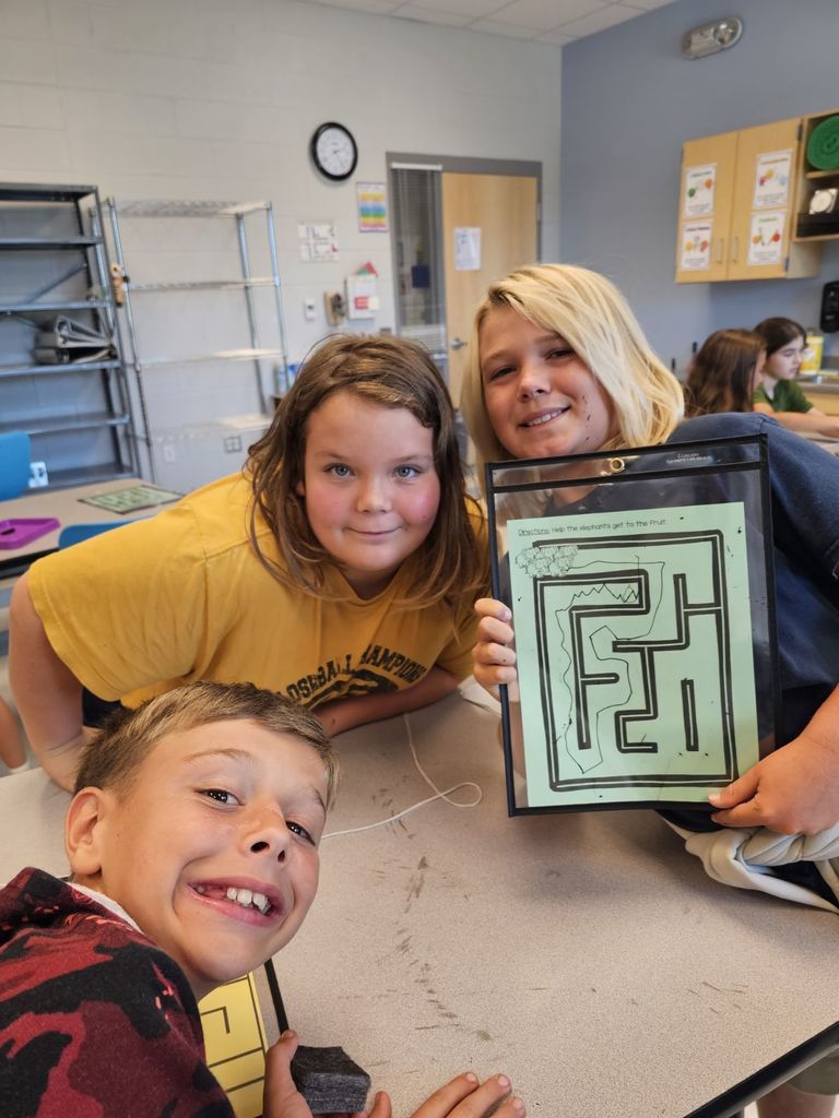 5th graders working in small groups on a maze project 