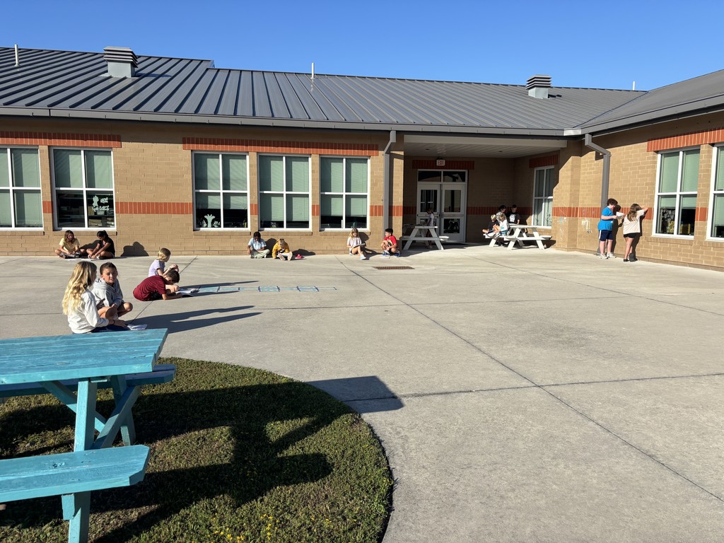 5th graders working on a project in pairs outside