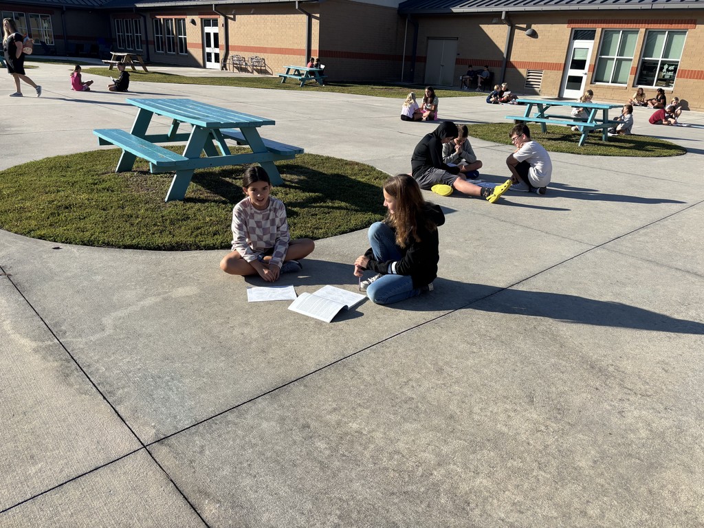 5th graders working on a project in pairs outside