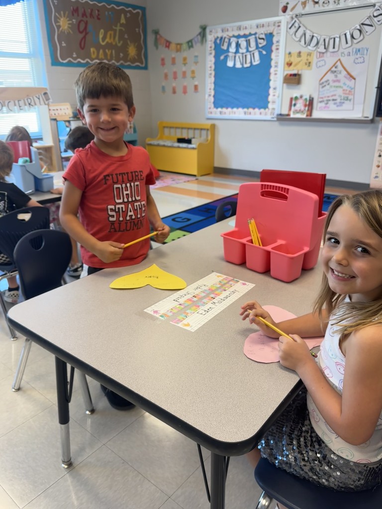 Kindergarten students working on a project at their tables