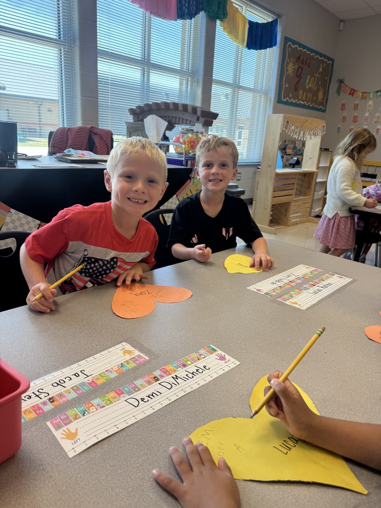 Kindergarten students working on a project at their tables