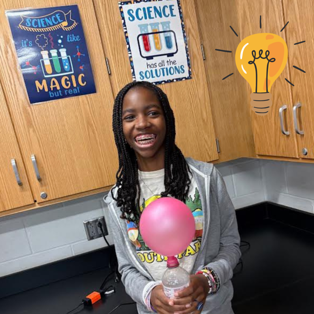 student holding balloon in water bottle for science lab