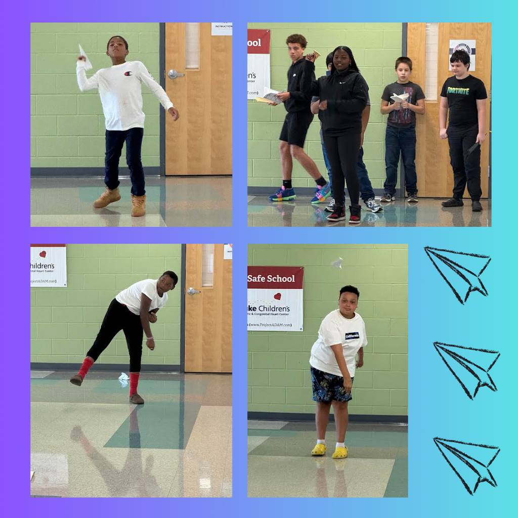 students testing paper airplanes in hallway