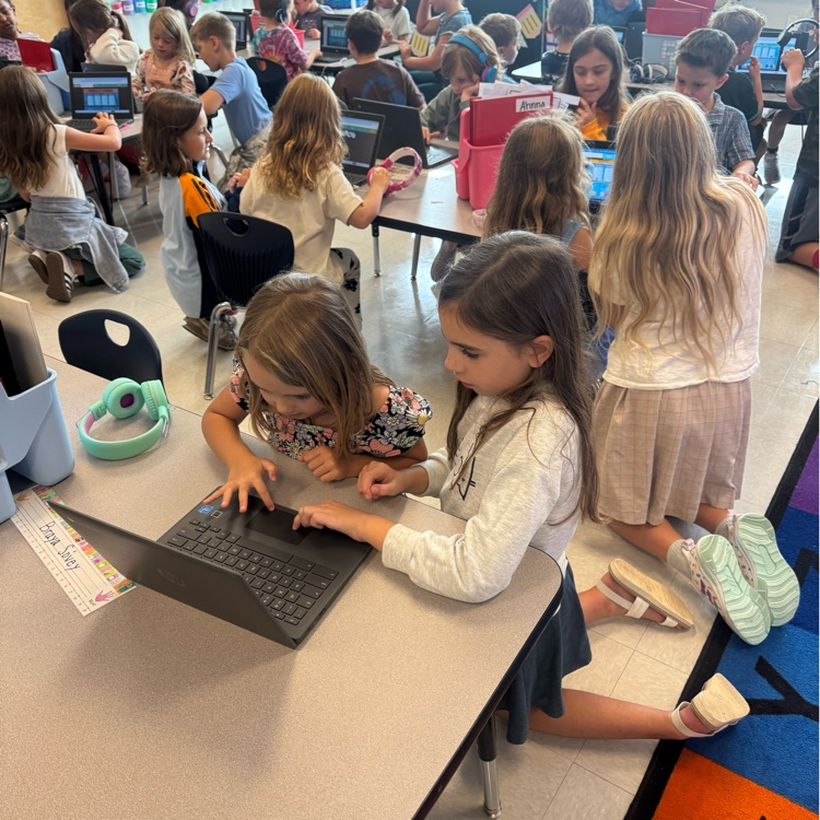 4th grader helping a kindergarten kid with their Chromebook 