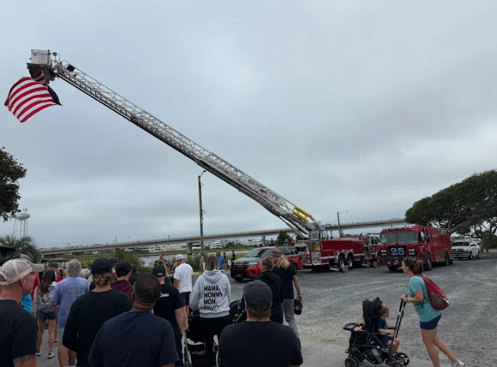 fire truck with raised flag on ladder