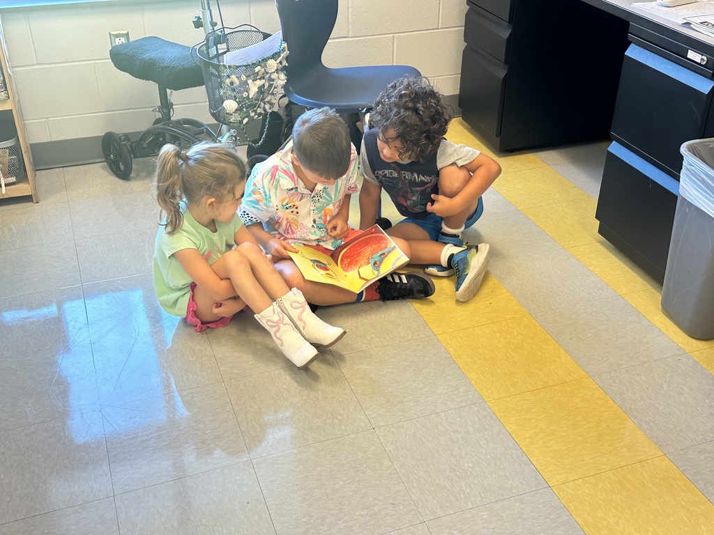 1st graders looking at a book in a small group