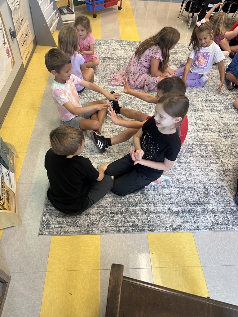 1st graders sitting on the carpet working on math fact fluency 