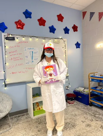 Ms. Lagnese dressed up in medical gear holding a book