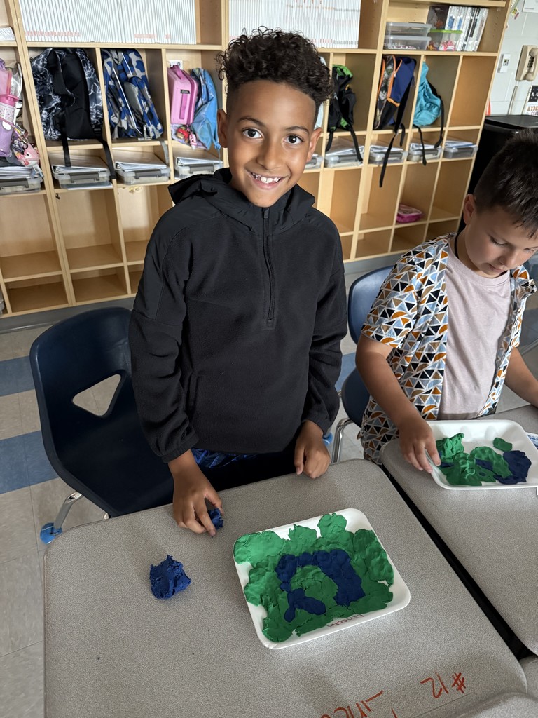 3rd graders using dough to create landforms and water