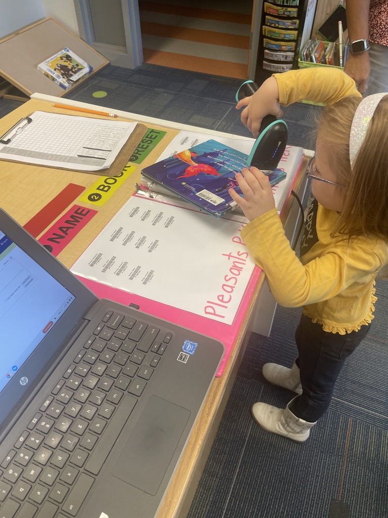 PreK students scanning out their library books