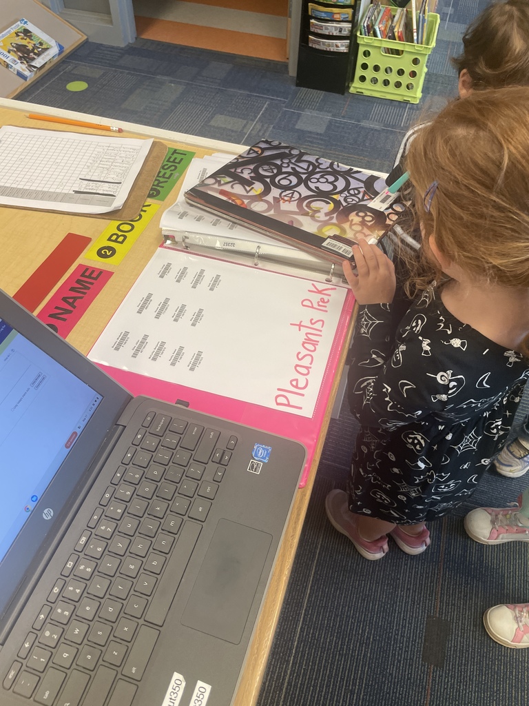 PreK students scanning out their library books
