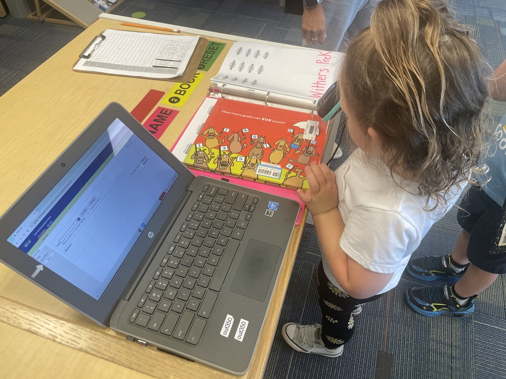 PreK students scanning out their library books