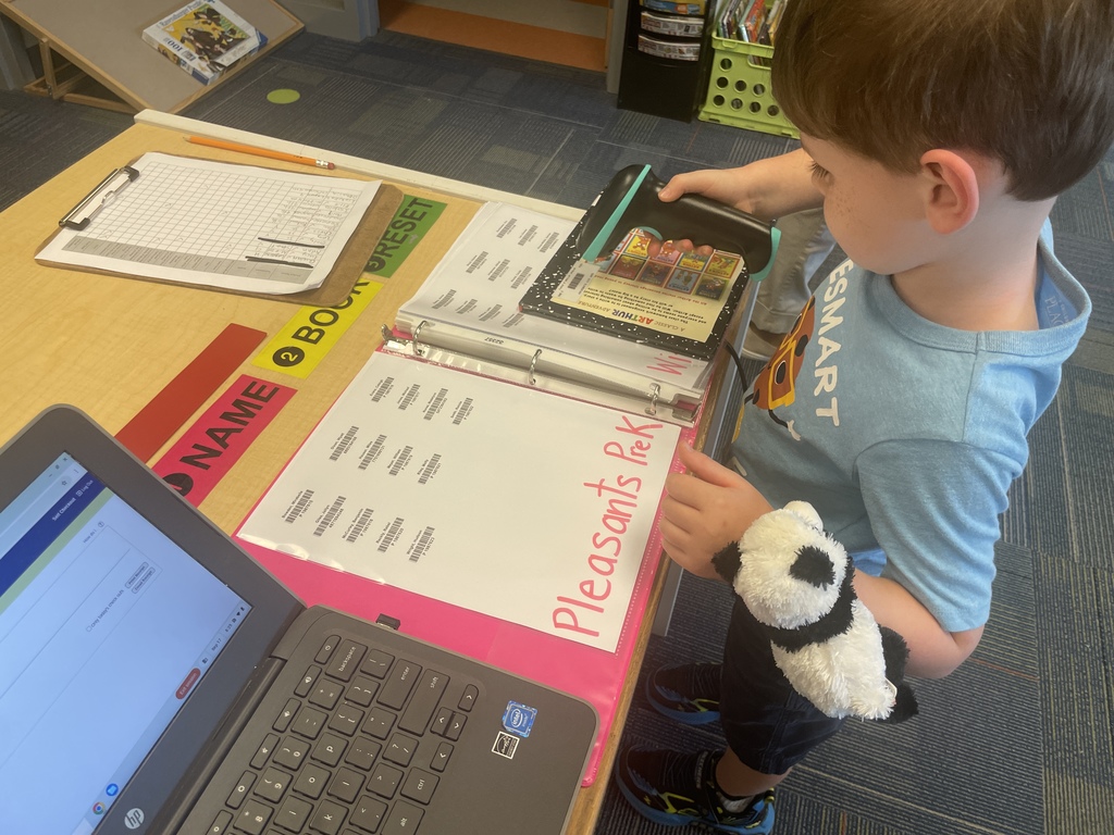 PreK students scanning out their library books