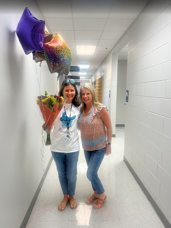 Mrs. Wood receiving an award with flowers and balloons