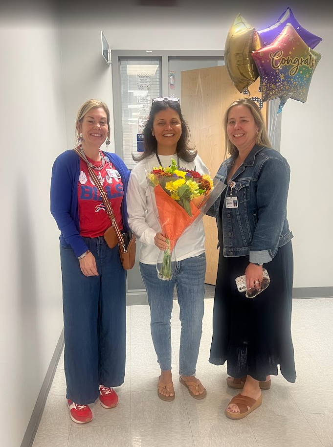 Mrs. Wood receiving an award with flowers and balloons