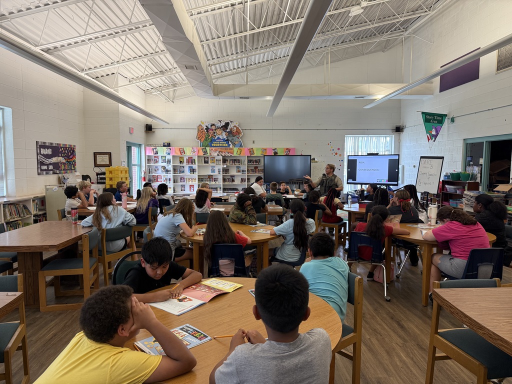 Students in library learning with dare instructor 