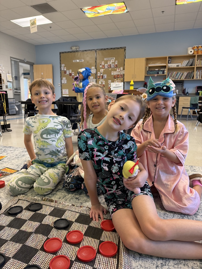 first grader working on the carpet and holding a stuffed animal