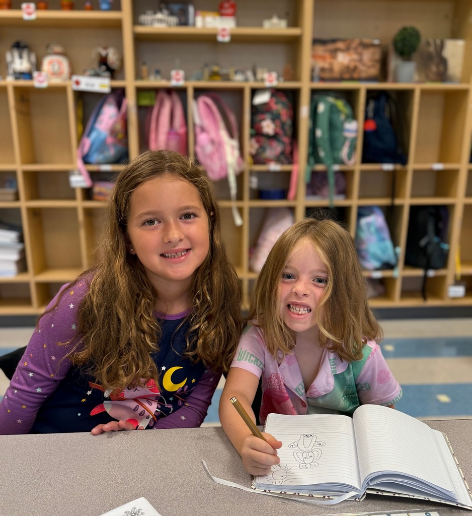 first grade students working together at their table wearing pajamas 