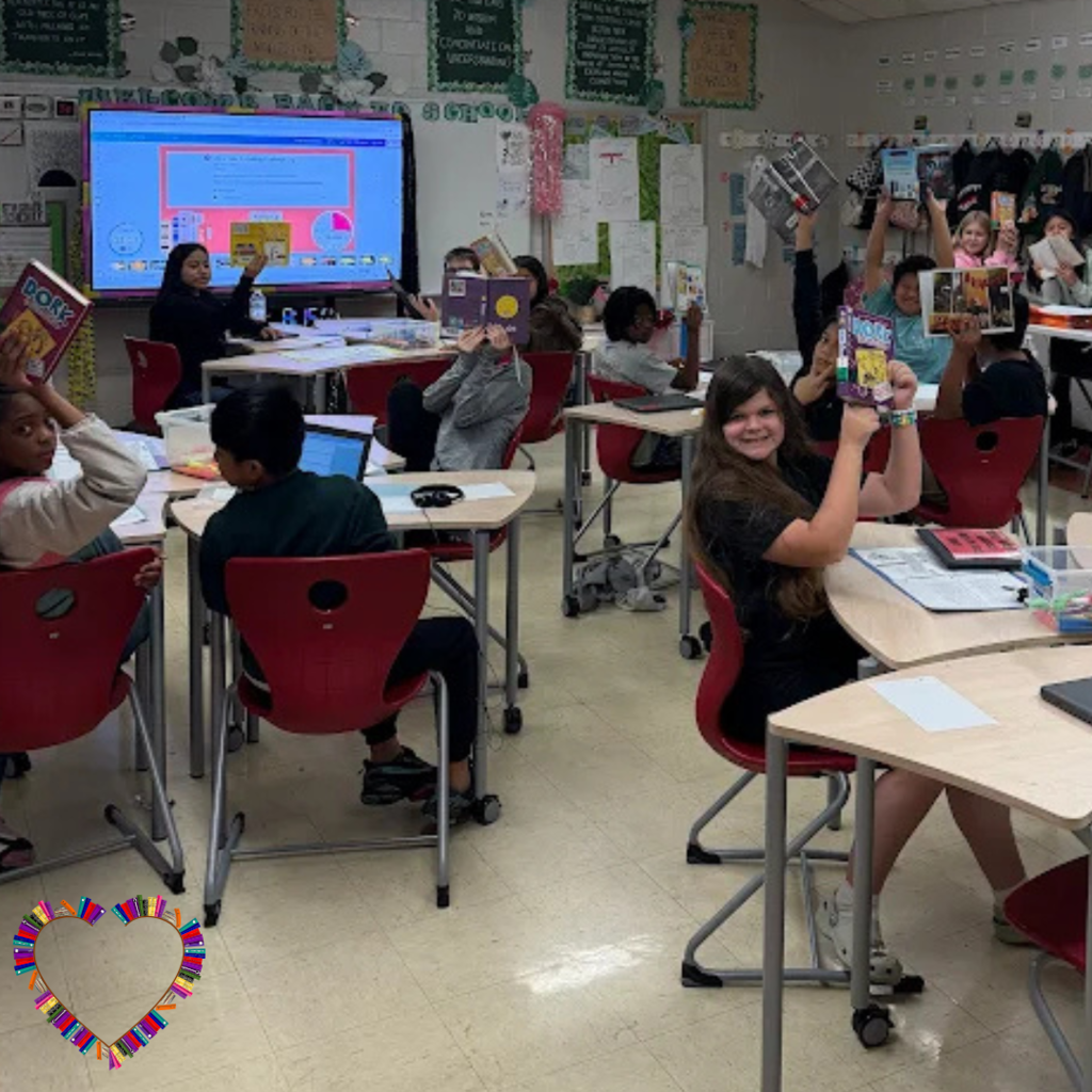 students holding up books they are reading in the classroom