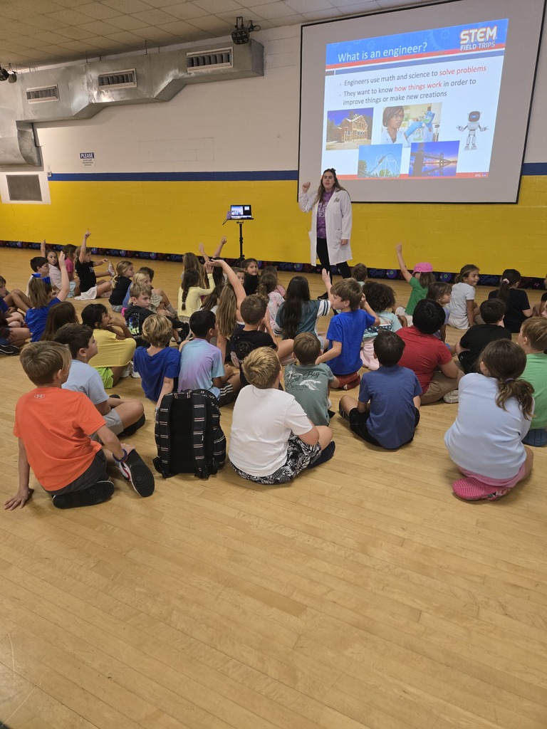 3rd graders listening to a roller-sktating engineer presentation