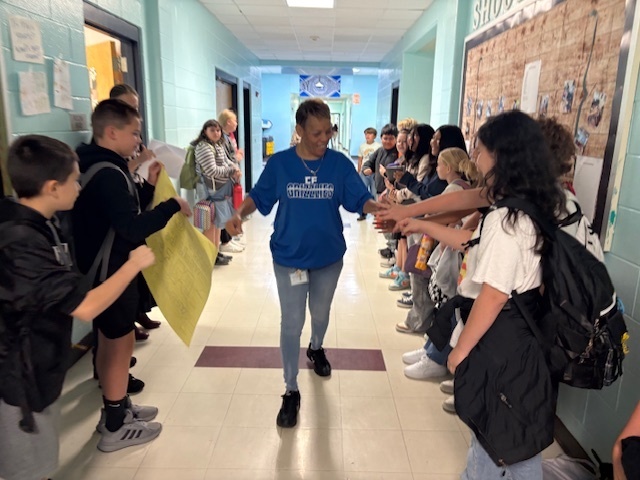 Ms. Brenda walking down the hallway getting high fives for National Custodian Day.